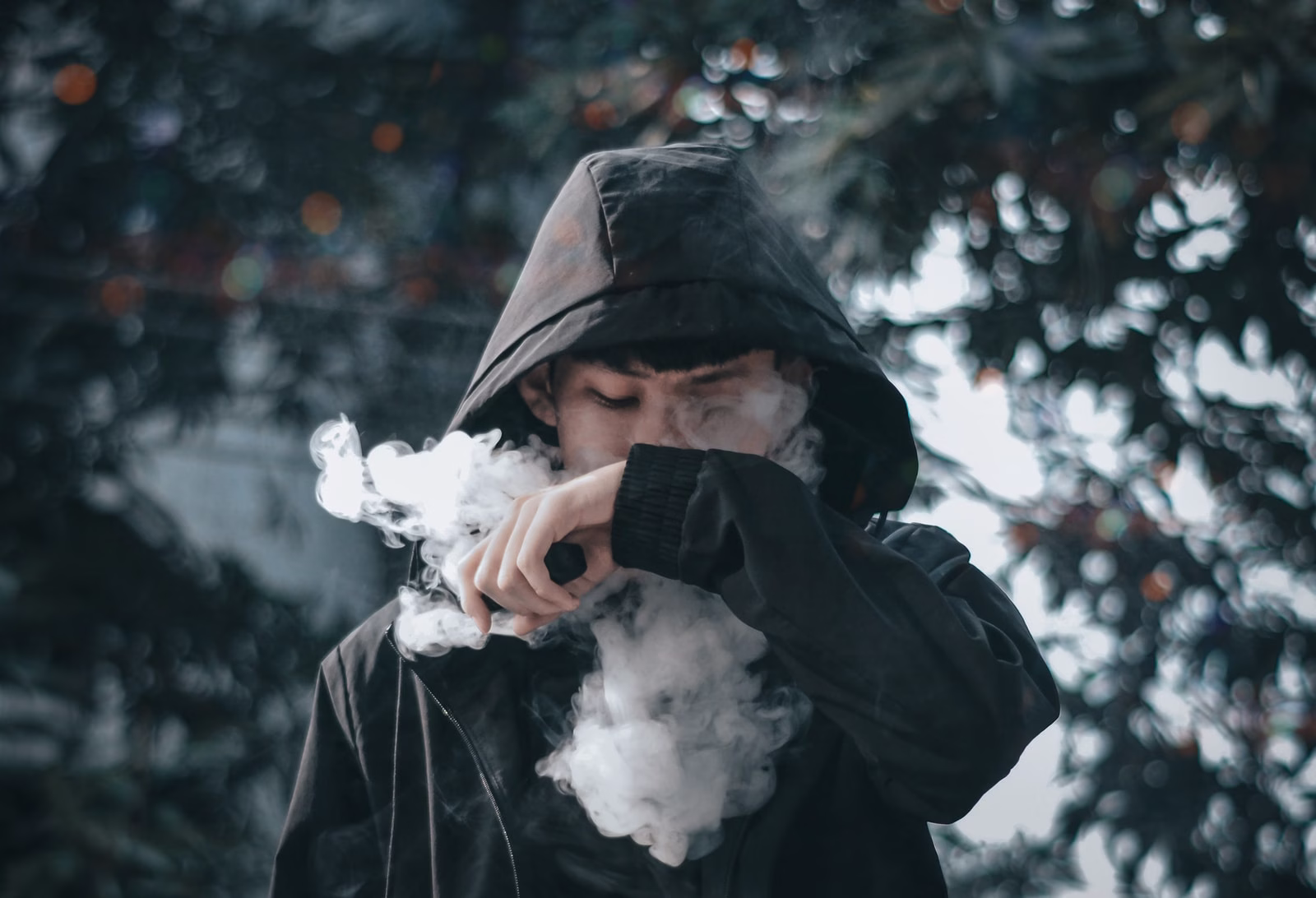man in black hoodie holding white flower